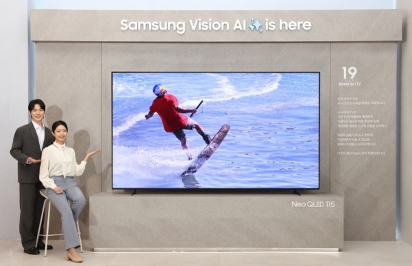 두 명의 모델이 삼성 비전 AI가 적용된 Neo QLED 115 TV를 소개하고 있으며, TV 화면에는 수상 스포츠를 즐기는 사람이 보인다.